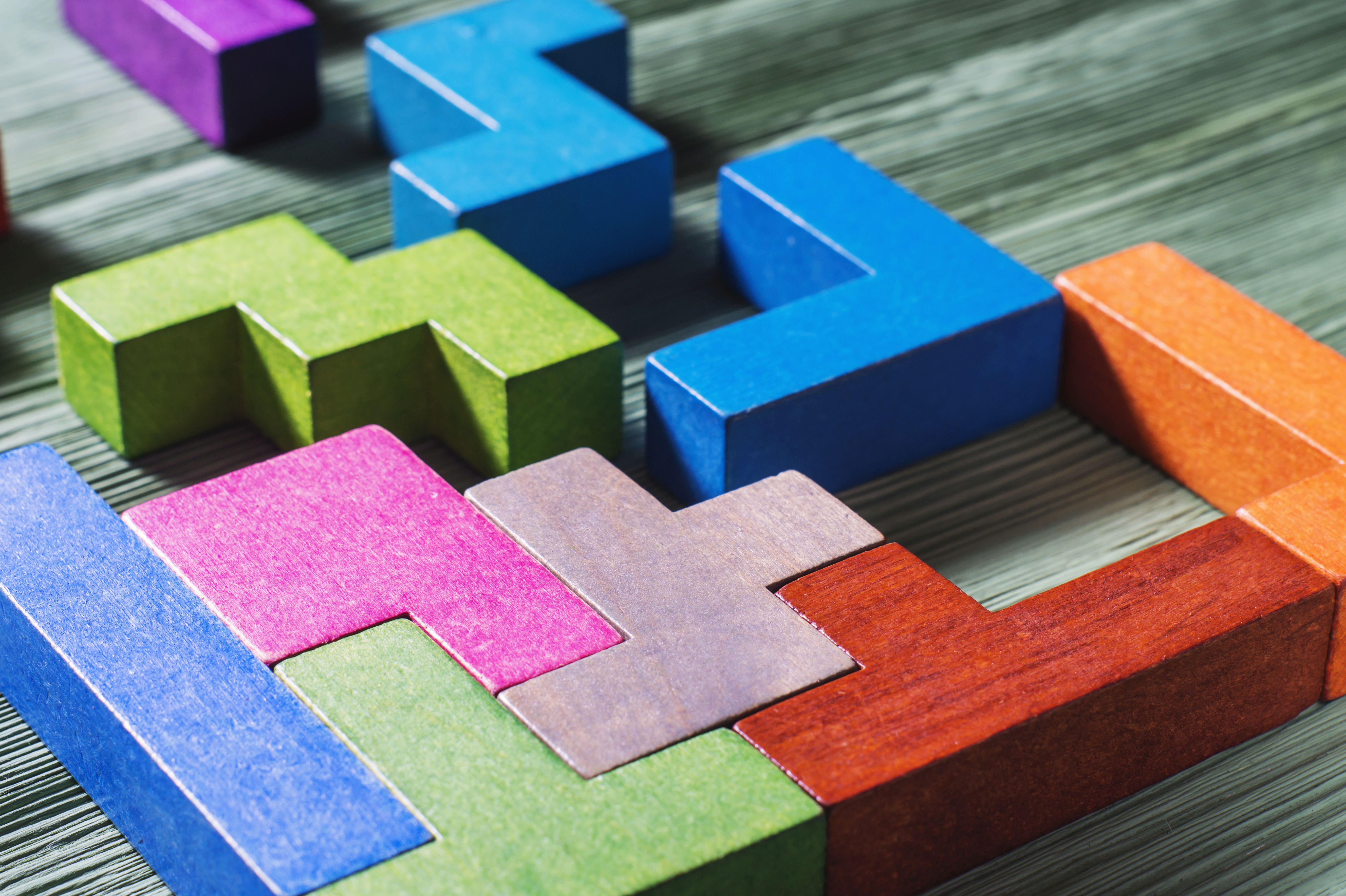 The concept of logical thinking. Geometric shapes on a wooden background.  Tetris toy wooden blocks.