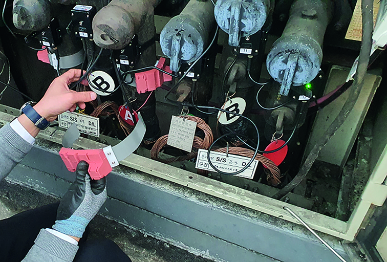 Installation of sensors at elbow connectors in ground switchgear.