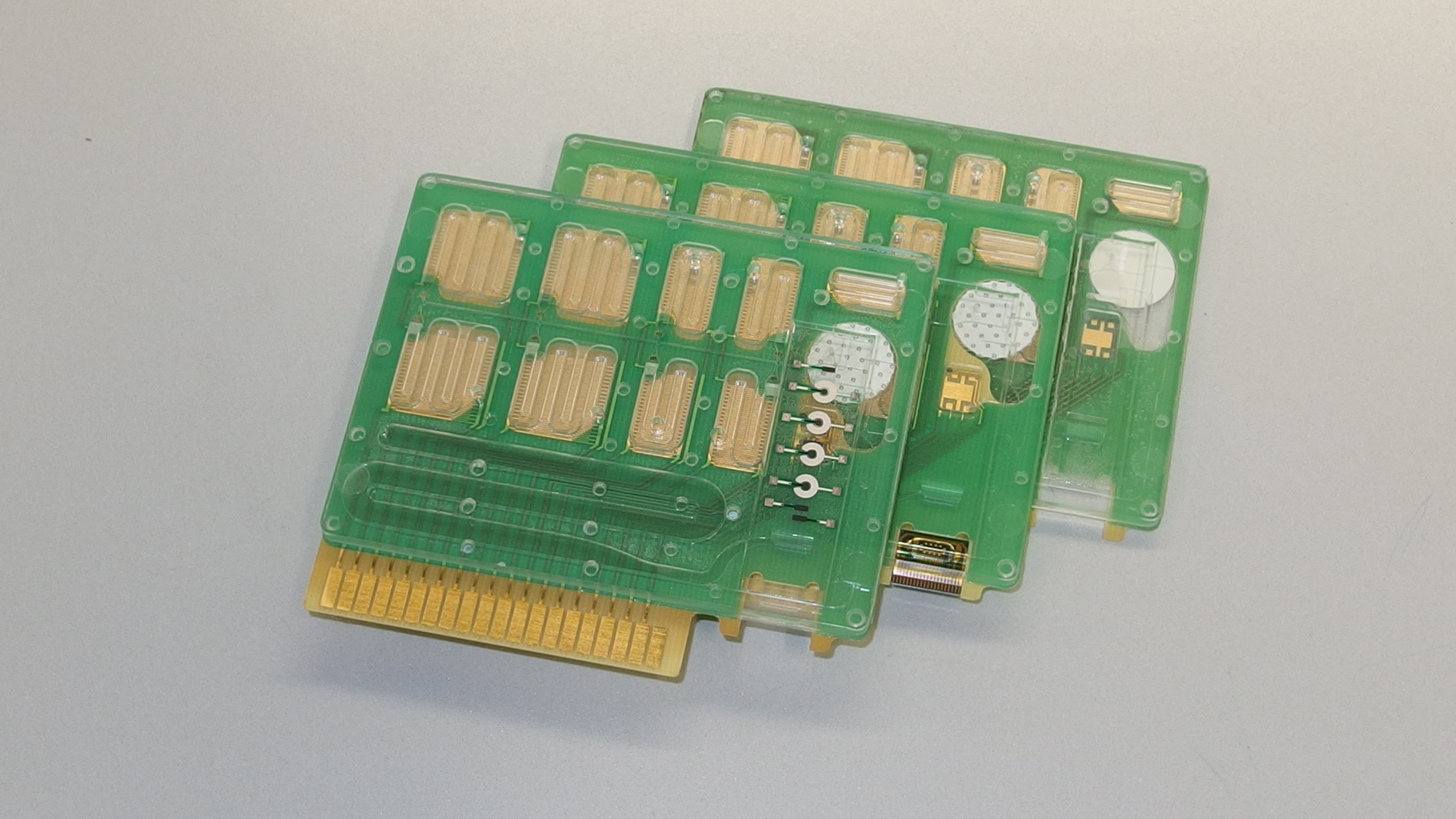 Microfluidic cartridges with different biosensors: screen printed electrochemical biosensor, silicon biosensor and optical TIRF biosensor (left to right)